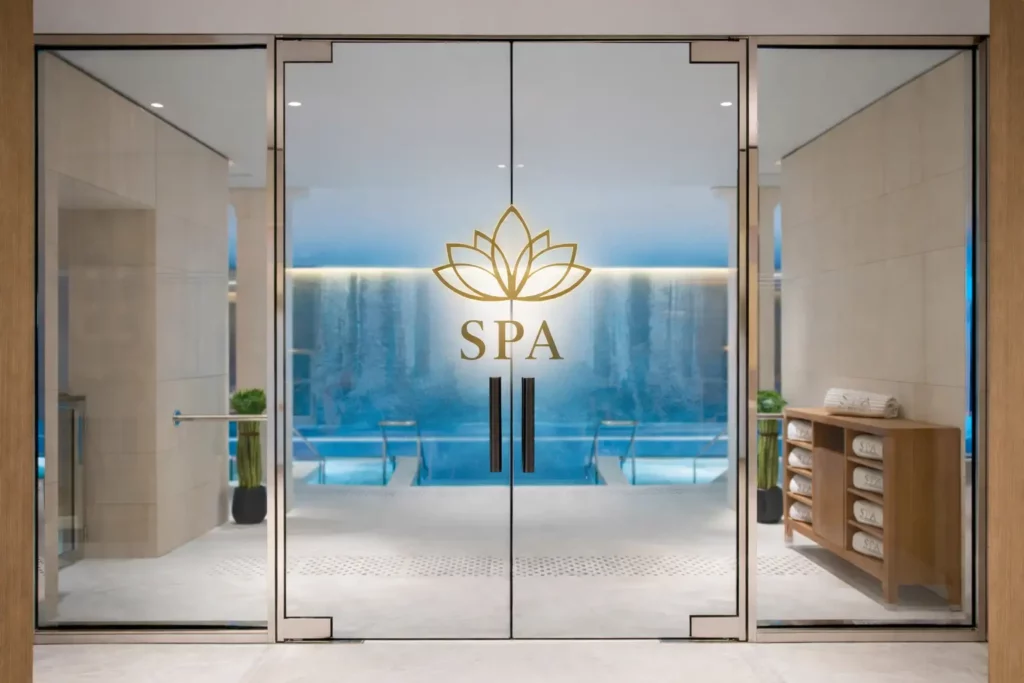 Porte vitrée d’entrée d’un spa avec logo lotus et inscription SPA sur vitrage dépoli